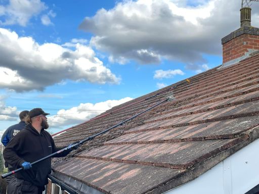 RnC roof cleaning operative safely cleaning moss & debris from roof tiles